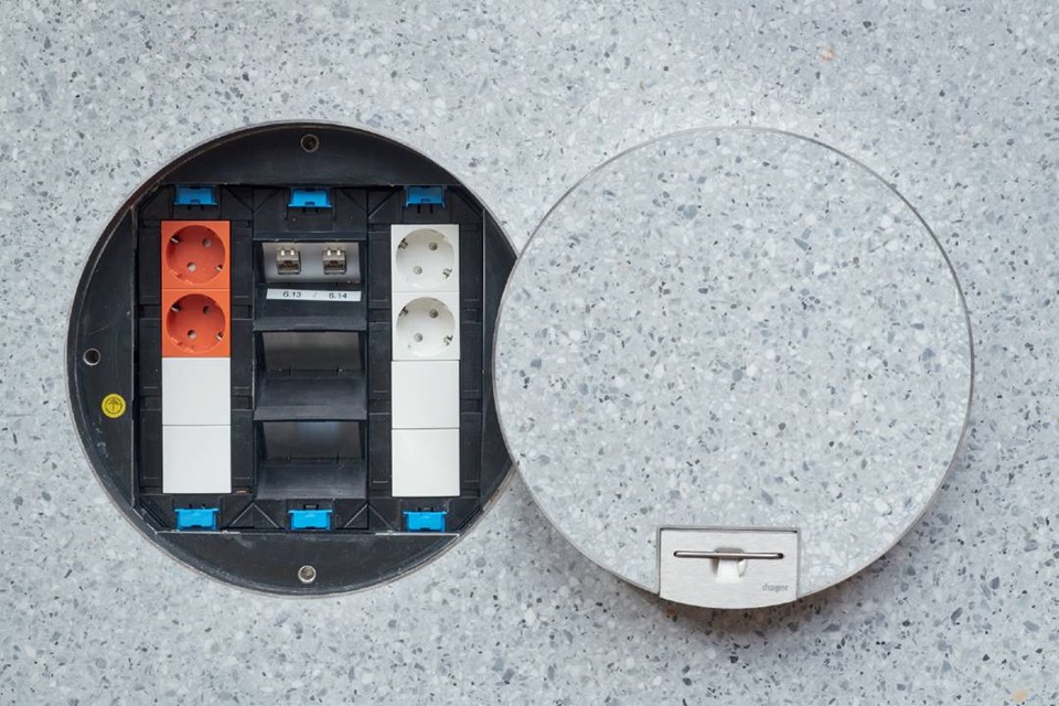 Open floor box with electrical outlets and RJ45 sockets ready for connectivity installation, Hager branding visible