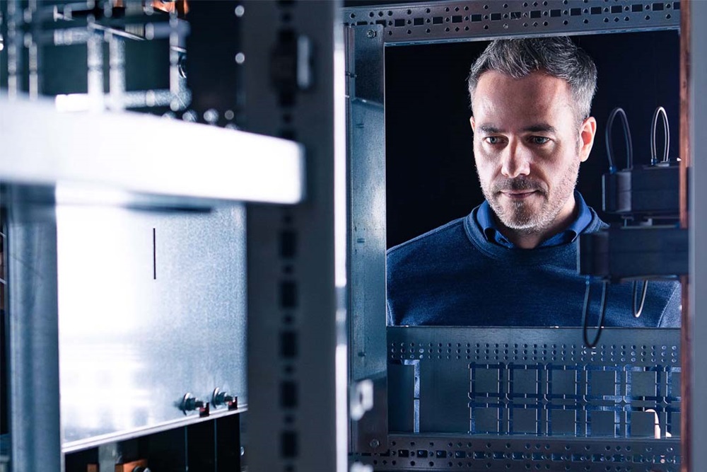 Professional examining an electrical cabinet with a focus on automation and control systems