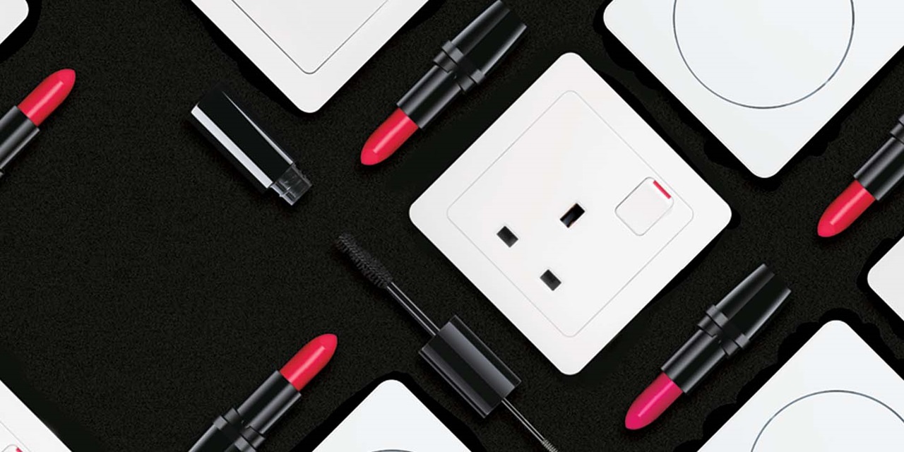 UK power socket and makeup products on a black background