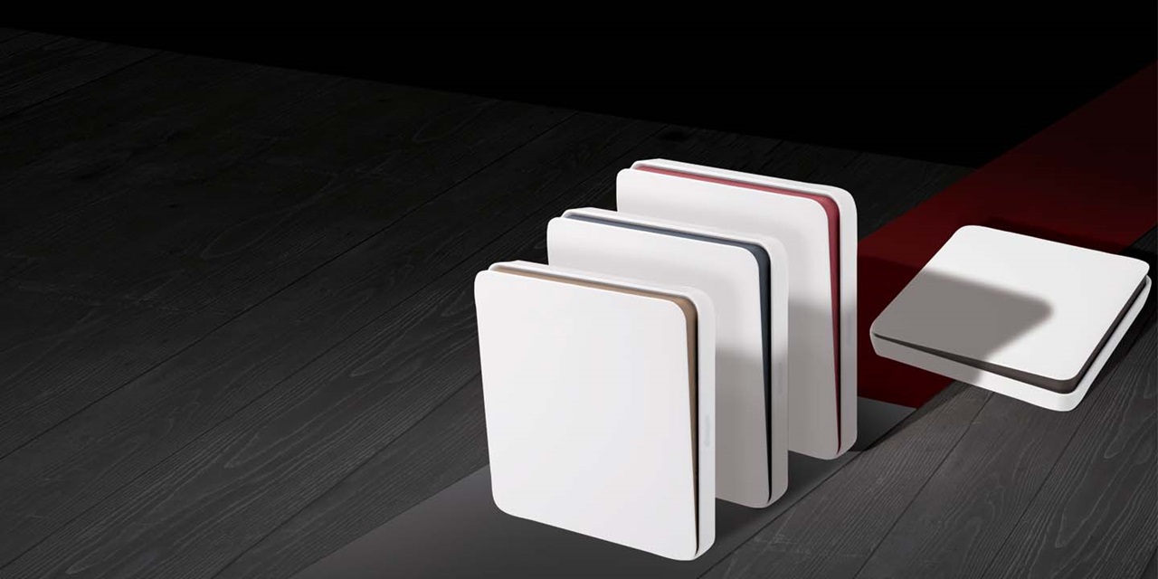Assortment of sleek white and red switch and socket covers on a dark wooden floor with a shadowy background
