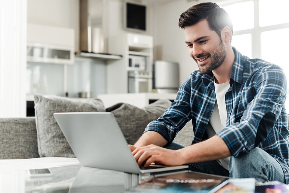 Person using a laptop in a modern living room setting